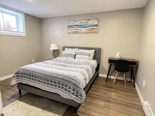 een slaapkamer met een bed en een bureau erin bij Charlottetown brand-new suite in Charlottetown