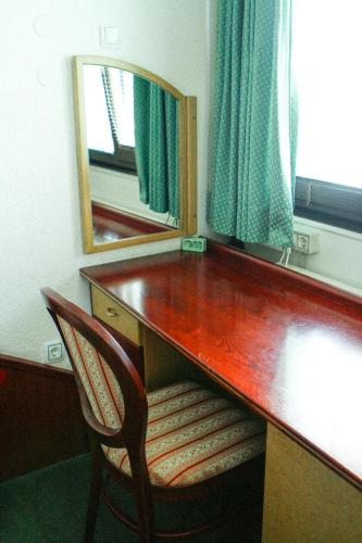 a desk with a chair and a mirror in a room at MC Hotel in Žalec