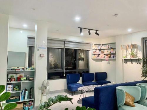 a living room with blue chairs and a couch at Snu Motel - Cao Bằng in Cao Bằng