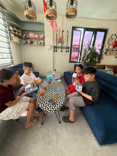 a group of children sitting on a couch eating food at Snu Motel - Cao Bằng in Cao Bằng