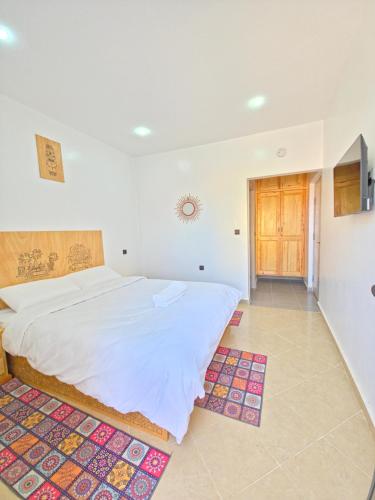 a bedroom with a large white bed in a room at LAFAMILIA SURF imsouane in Imsouane