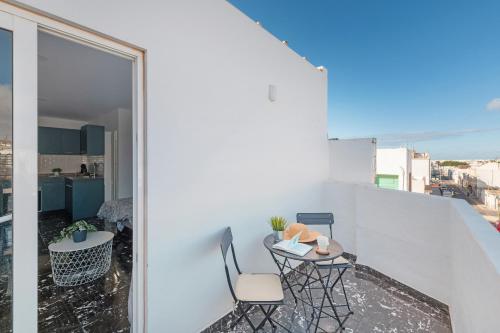 a balcony with a table and chairs on a white wall at Casa sofia in Argana
