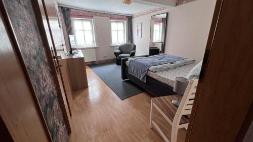 アイゼナハにあるFerienhaus zwischen Bach und Luther mit Saunaの部屋にベッドと椅子がある寝室