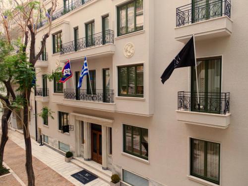 un edificio con bandiere a lato di Athens Capital Suites-MGallery Collection ad Atene