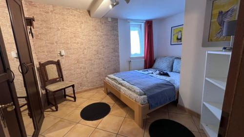 a small bedroom with a bed and a chair at Ferienhaus zwischen Bach und Luther mit Sauna in Eisenach