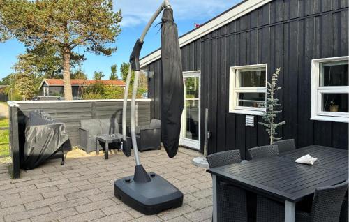 a black house with a table and a mop at Nice Home In Slagelse With Wifi in Stillinge Strand