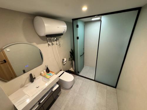 a bathroom with a sink and a toilet and a mirror at Cheng's Inn in Jingdezhen