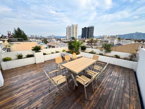 a wooden deck with a table and chairs on a roof at Cheng's Inn in Jingdezhen