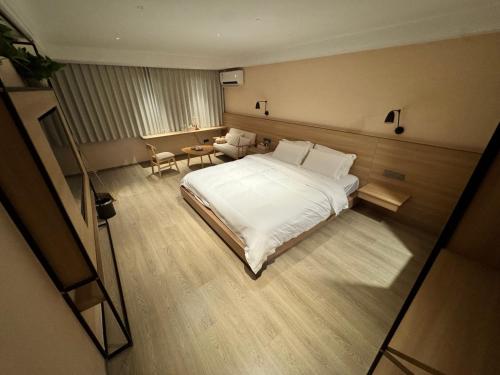 a bedroom with a large white bed and a table at Cheng's Inn in Jingdezhen