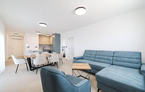 a living room with a blue couch and a table at Beautiful Apartment In Privlaka in Glavan