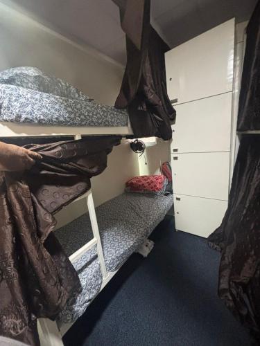 a small room with bunk beds and a closet at Kapoor dormitory in Mumbai