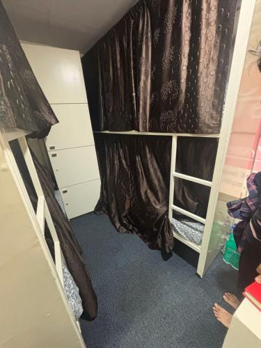 a small room with a curtain and a bed at Kapoor dormitory in Mumbai