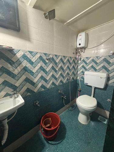 a bathroom with a white toilet and a sink at Kapoor dormitory in Mumbai