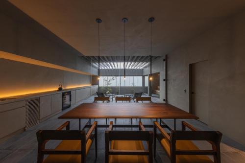 a dining room with a large wooden table and chairs at villa OCTOPORTO yobuko in Karatsu