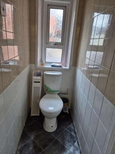 a small bathroom with a toilet and a window at Glendor Hotel in Blackpool