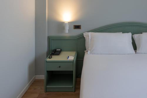 a bedroom with a bed with a phone on a night stand at Hotel Riva Del Sole in Giovinazzo
