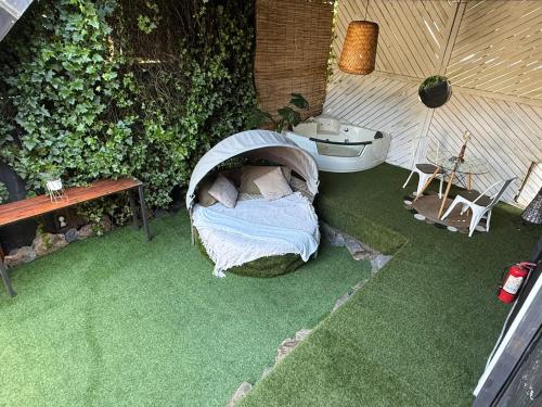 a small garden with a bed and a bath tub at Casa Panal , Jacuzzi opcional Villa Alemana in Villa Alemana