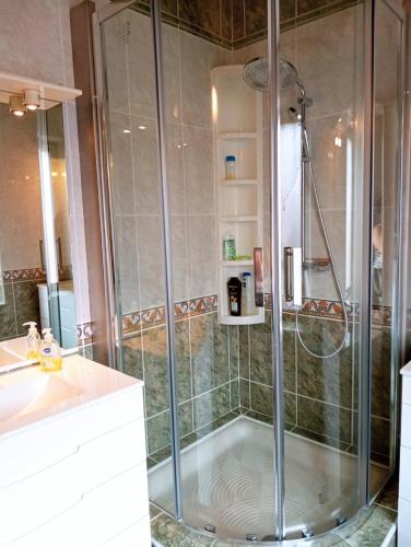 una doccia con una porta in vetro in un bagno di Maison 4 chambres, climatisée, terrasse, garage cadre paisible 8EGLI10 a Canet-en-Roussillon