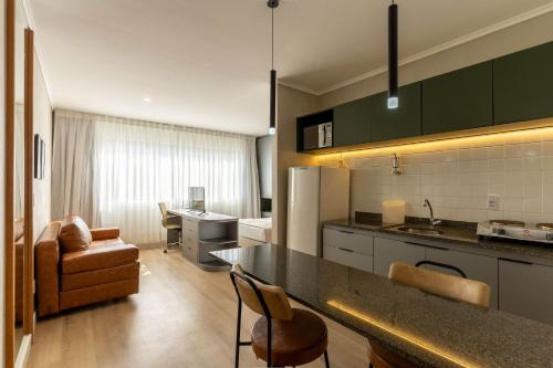 eine Küche mit grünen Schränken und ein Wohnzimmer in der Unterkunft Multiparque Hplus Long Stay in Brasilia