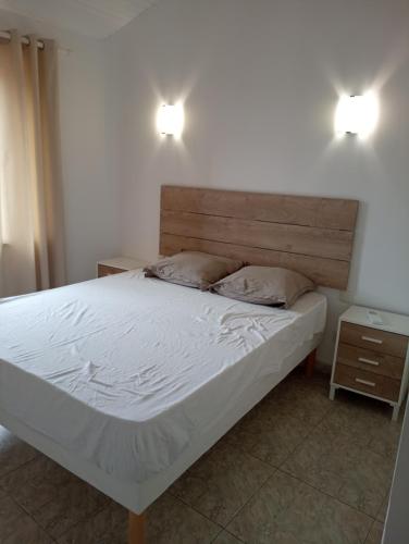 un letto con due cuscini sopra in una camera da letto di Maison 4 chambres, climatisée, terrasse, garage cadre paisible 8EGLI10 a Canet-en-Roussillon