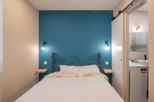 une chambre avec un mur bleu et un lit dans l'établissement Bâtiment Les Iris, à Bourg-Saint-Andéol