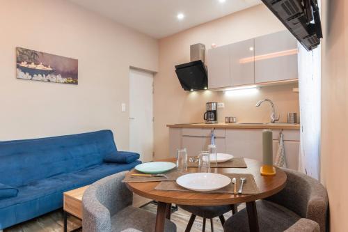 un salon avec une table et un canapé bleu dans l'établissement Bâtiment Les Iris, à Bourg-Saint-Andéol