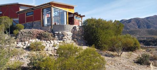 ein Haus auf einem Hügel mit Bergen im Hintergrund in der Unterkunft Cabaña La Ermita, Complejo El Taller in Ciudad Lujan de Cuyo