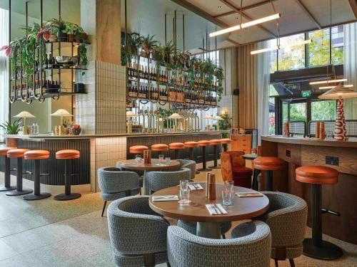 a restaurant with tables and chairs and a bar at TRIBE London Canary Wharf in London