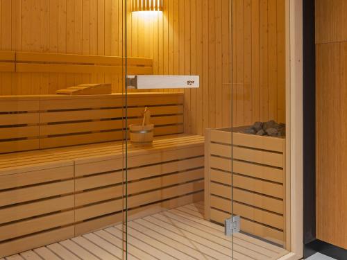 a sauna with wooden walls and a glass door at Mercure Namur Hotel in Namur
