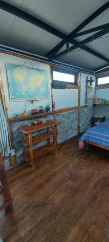 Zimmer mit einem Bett und einem Holztisch in der Unterkunft Cabaña La Ermita, Complejo El Taller in Ciudad Lujan de Cuyo