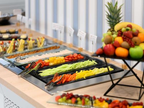 a buffet line with fruits and vegetables on display at Mövenpick Balaland Resort Lake Balaton in Szántód
