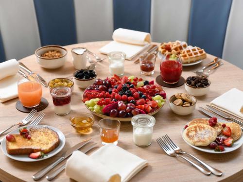a table topped with plates of food and breakfast foods at Mövenpick Balaland Resort Lake Balaton in Szántód
