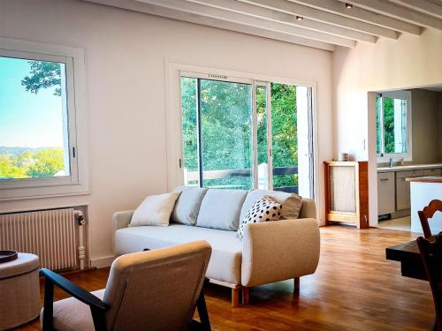 un salon avec un canapé et quelques fenêtres dans l'établissement Villa Hortensia - Charming Cottage Near Fontainebleau, à Veneux-les-Sablons