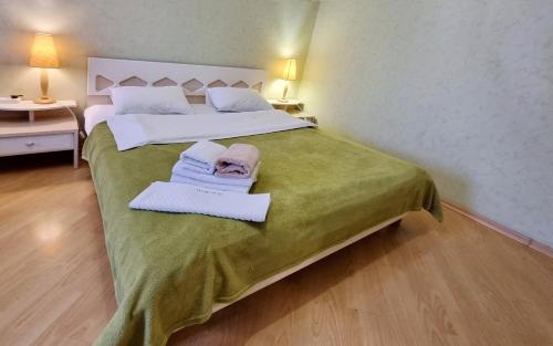 a bedroom with a large bed with towels on it at Home Hotel Apartments on Livoberezhna in Kyiv