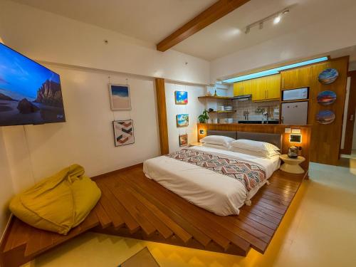 a bedroom with a large bed and a kitchen at Aqua Horizon Beachside Condo I Signature Art Suites in Dauis
