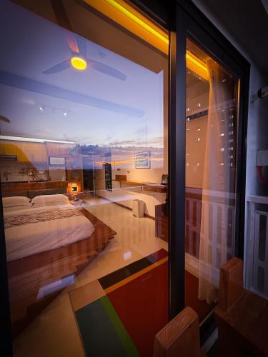 a bedroom with a bed and a large window at Aqua Horizon Beachside Condo I Signature Art Suites in Dauis