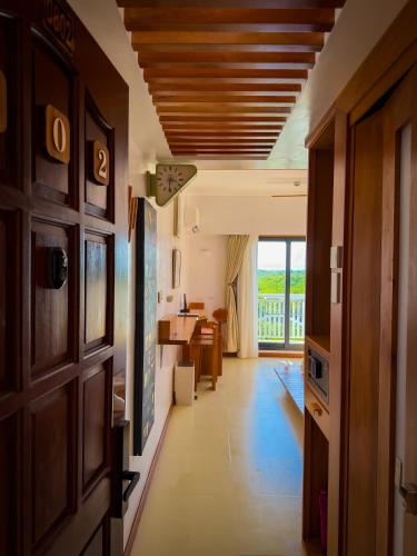 a hallway with a door and a kitchen with a table at Aqua Horizon Beachside Condo I Signature Art Suites in Dauis