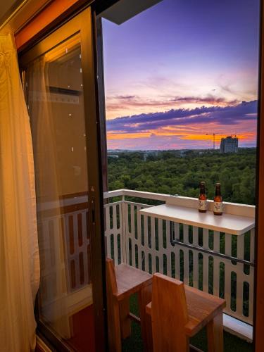 a balcony with a table and chairs and a sunset at Aqua Horizon Beachside Condo I Signature Art Suites in Dauis