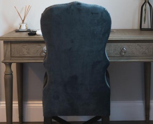 a green chair sitting in front of a desk at The Hart Uttoxeter in Uttoxeter