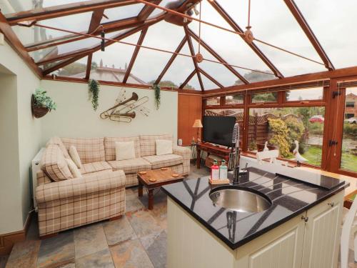 a kitchen and living room with a glass roof at Beckside Cottage in Penrith