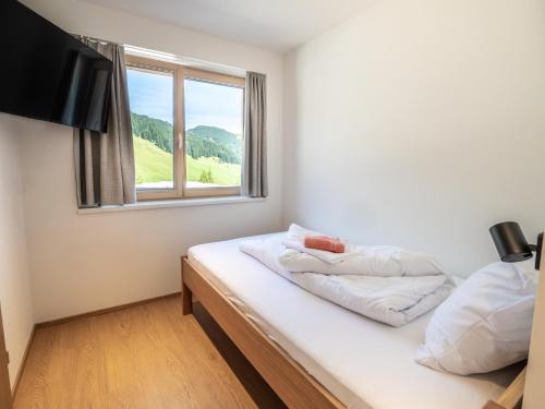 two beds in a room with a window at Appartements Basecamp Warth in Warth am Arlberg