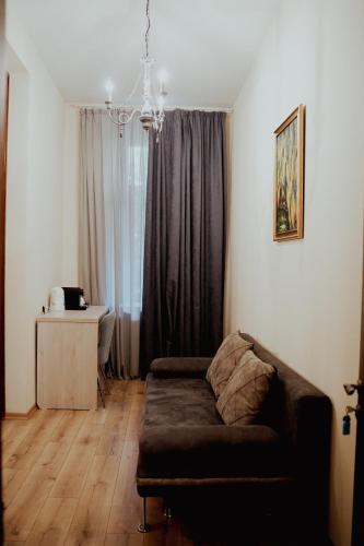 a living room with a couch in front of a window at Hotel Griboedov in Tbilisi City