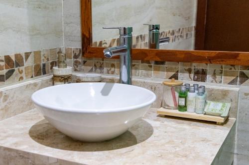 a white bowl sink in a bathroom with a mirror at Bella Gamboa Casa de Praia - Gamboa, Morro de São Paulo - in Gamboa