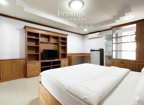a bedroom with a large bed and a kitchen at Prestige in Bangna