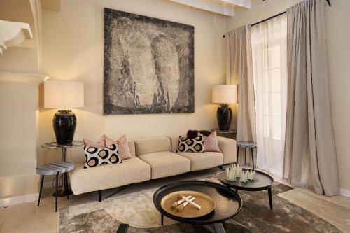 ein Wohnzimmer mit einer Couch und zwei Tischen in der Unterkunft Villa Cas Pilot Casa Mallorquina del Siglo XVIII NEW OPENING in Son Servera