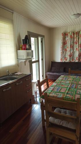 cocina con mesa y fregadero en una habitación en Chalé Paraíso Da Serra 02, en Gramado