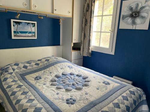 une chambre avec un lit avec un mur bleu dans l'établissement Cap esterel magnifique T3, à Saint-Raphaël