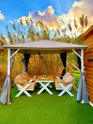 a gazebo with chairs and a table on grass at בקתה 21 in Yuval