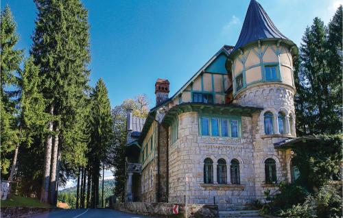 a large stone house with a turret on top at Amazing Home In Podstene in Kupa