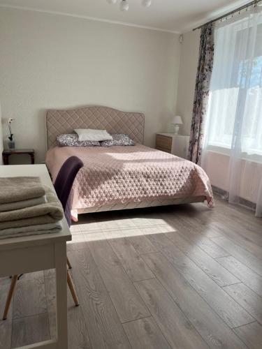 a bedroom with a bed and a wooden floor at FAMILY HOUSE MARUPE in Mārupe